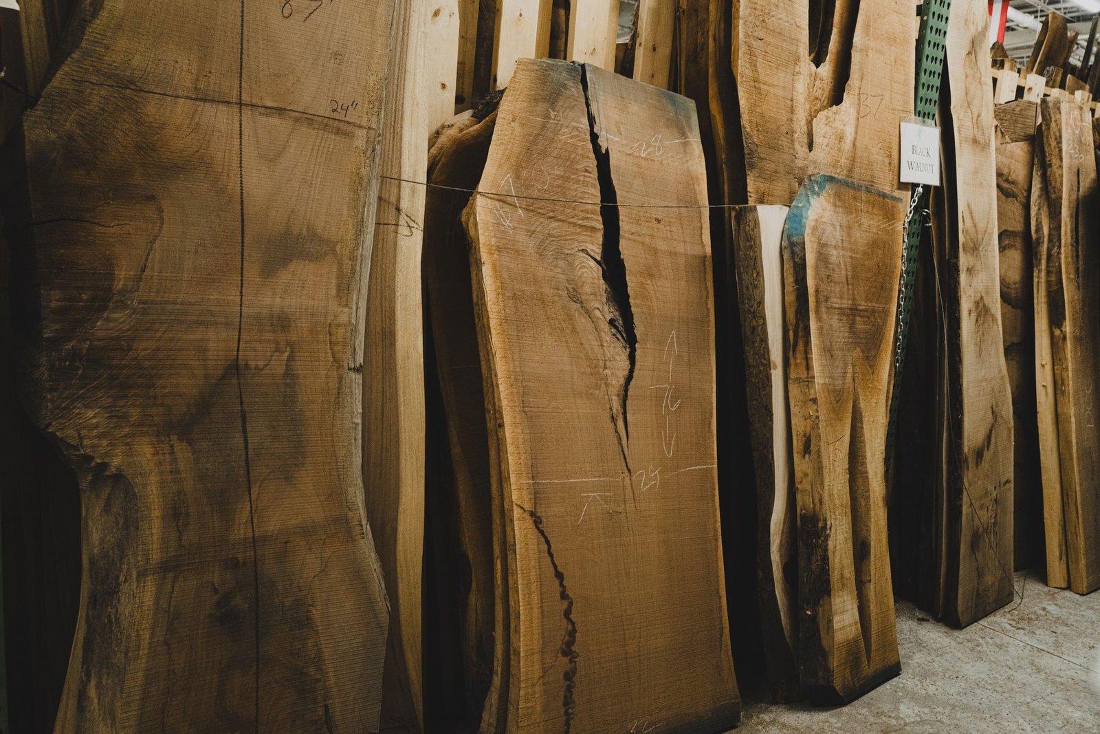 Tall live edge slabs standing in our slab room, marked with their sizes